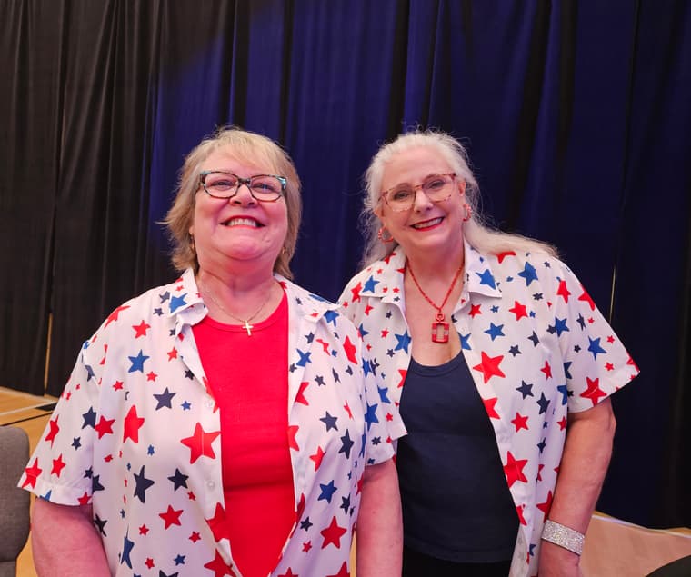 Two members smiling together in star-patterned shirts