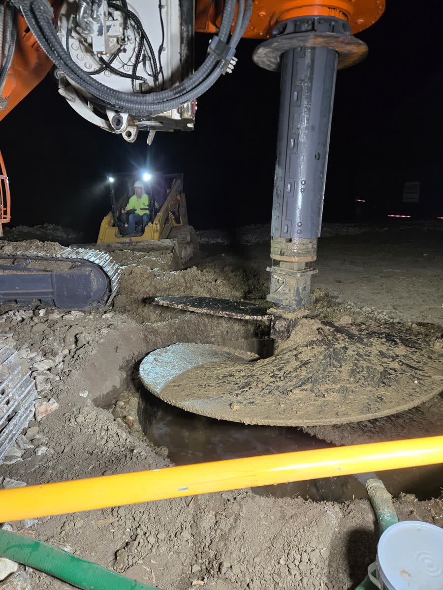 Night drilling with a large auger on a lit job site