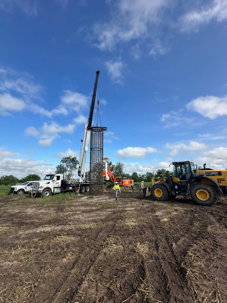Drill rig and loader working on an open job site