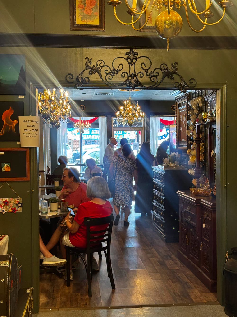 Inside Vintage Style — brass chandeliers over the dining room with the vendor booths beyond