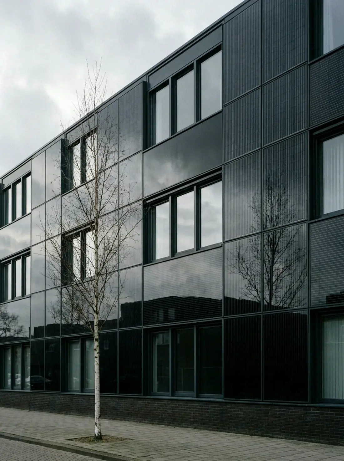 Moderne gevel bekleed met zwarte fotovoltaïsche glaspanelen