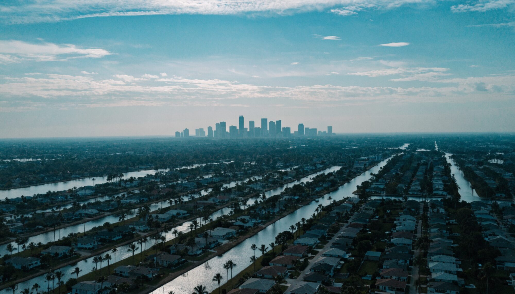 Aerial view of Miami-Dade neighborhoods with the Miami skyline on the horizon
