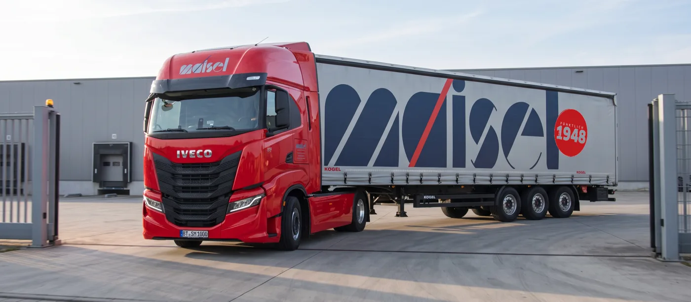 Roter IVECO S-Way von Maisel mit Kögel-Auflieger bei der Einfahrt in einen Betriebshof