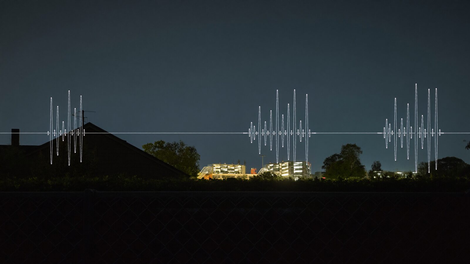 Suburban backyard at night behind a fence line, a data-center glow on the horizon and an octave-band frequency curve overlaid on the sky