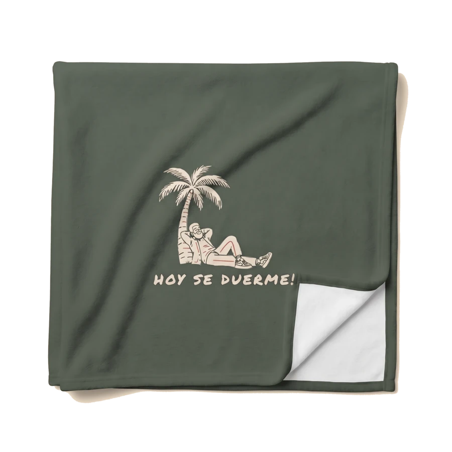 Folded olive Hoy Se Duerme blanket with printed character and white reverse