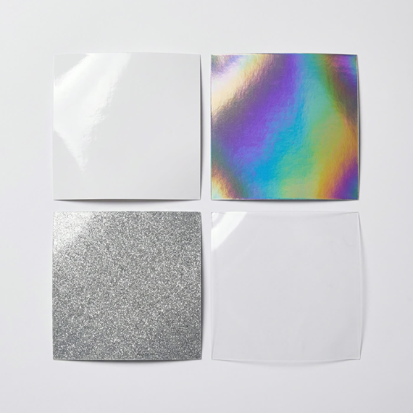 Sticker material swatches: glossy white vinyl, holographic, glitter and clear film