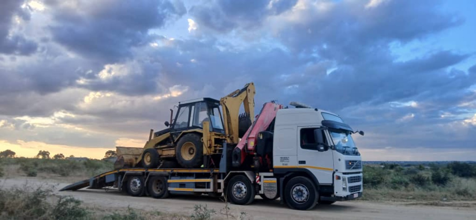 Backhoe loader transported on a PONK crane truck